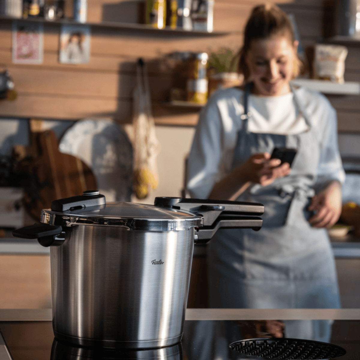 Ein Fissler Edelstahl-Schnellkochtopf auf einer modernen Herdplatte, der deutsche Präzision und zeitloses Design in der Küche präsentiert.