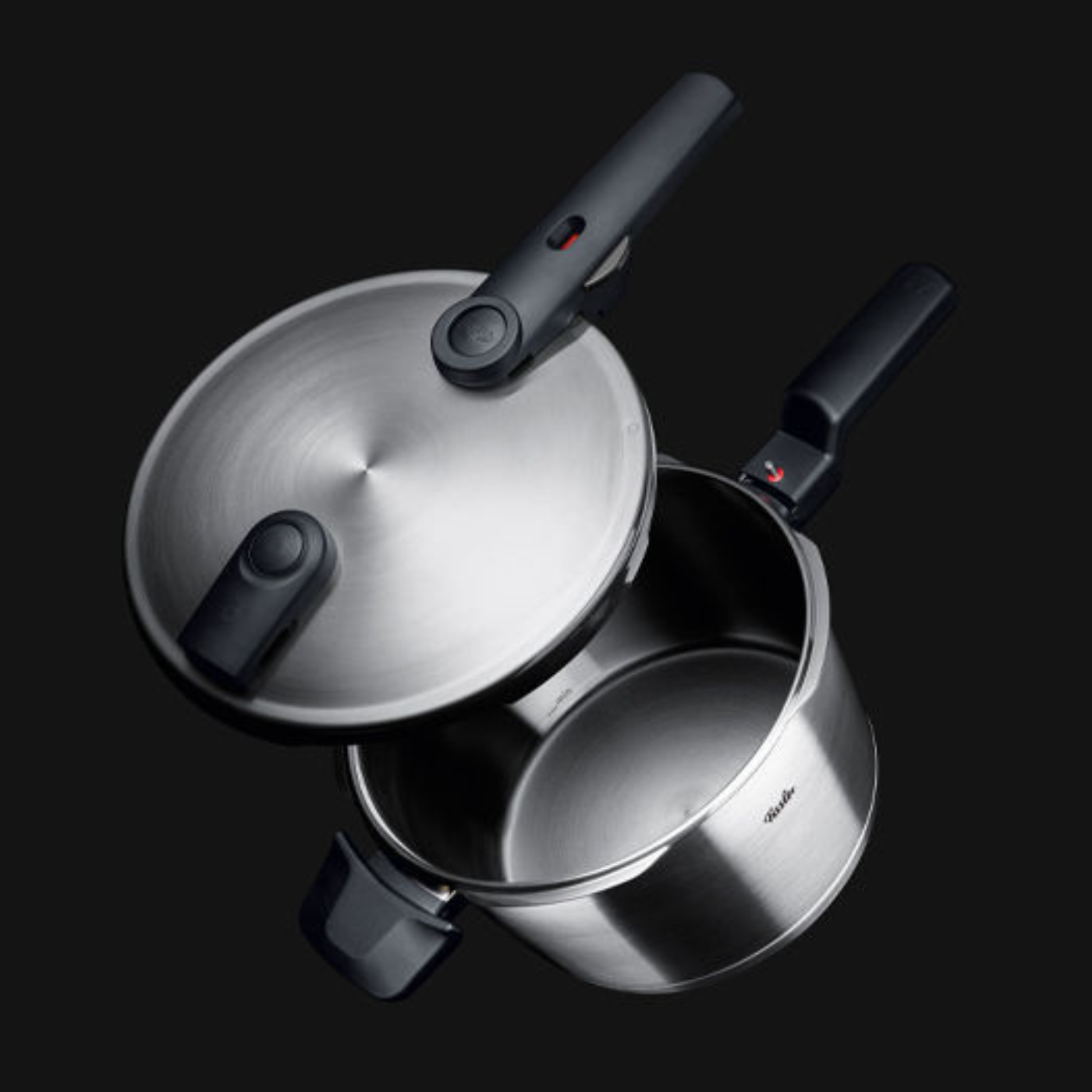 Fissler Schnellkochtopf aus rostfreiem Stahl mit ergonomischem schwarzem Griff, offenem Deckel und schlankem deutschen Design vor schwarzem Hintergrund.
