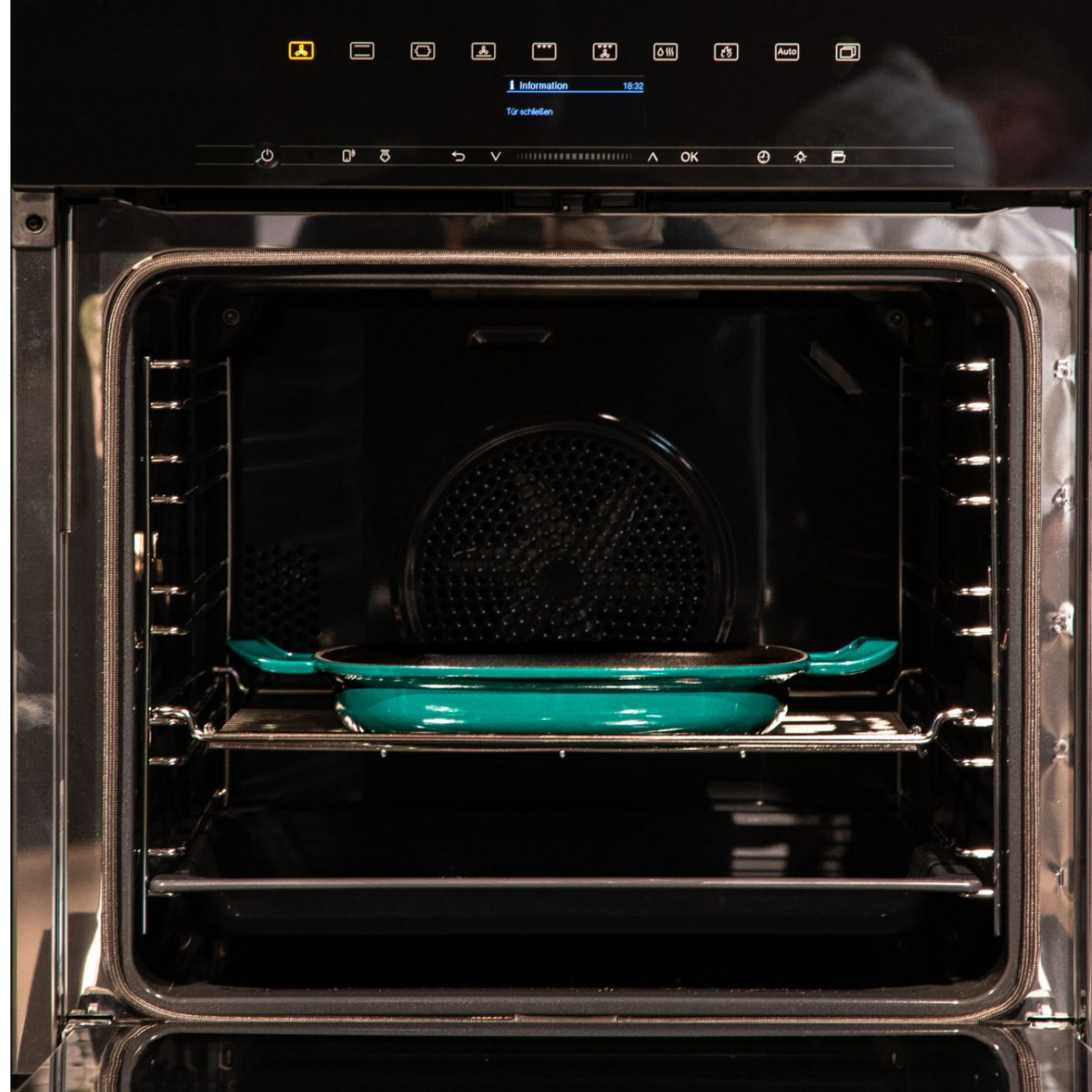 Eine hochwertige tealfarbene Fissler-Backform, die sich durch Langlebigkeit und zeitloses Design auszeichnet, ruht in einem Ofen unter einem digitalen Bedienfeld.