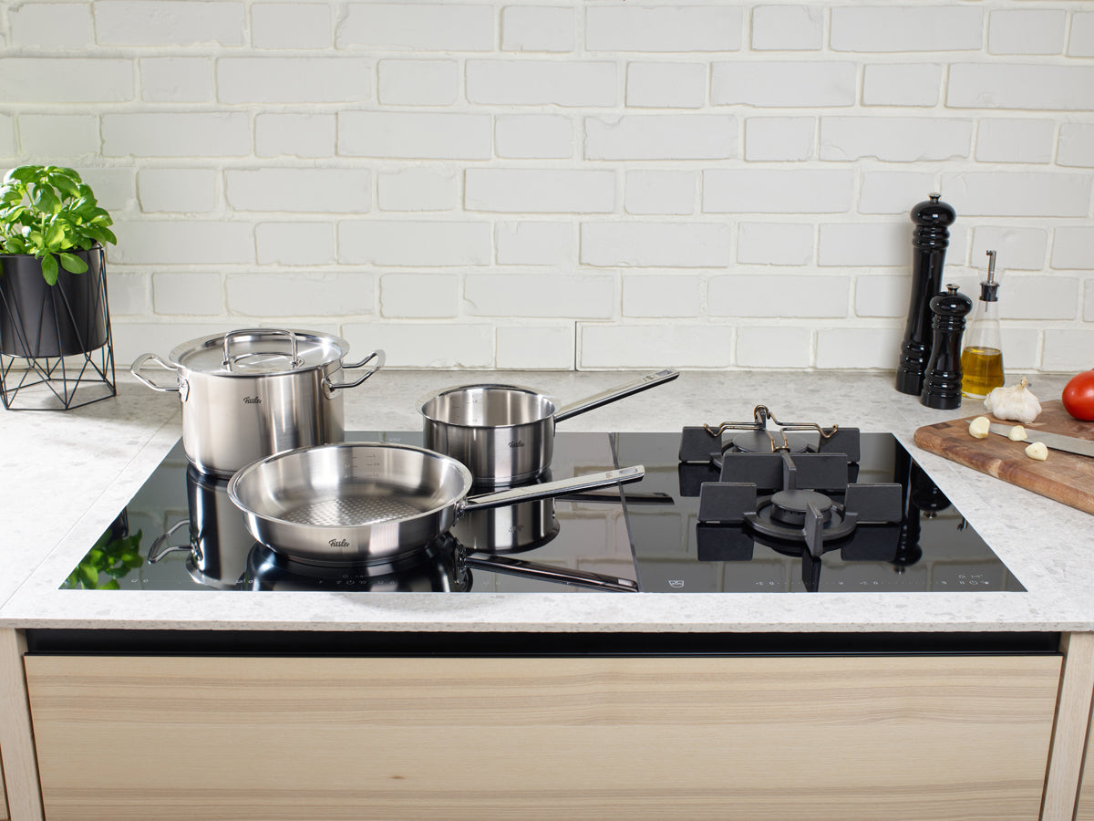 An elegant kitchen featuring Fissler Original-Profi Collection® cookware and fresh ingredients, showcasing German precision and timeless design.
