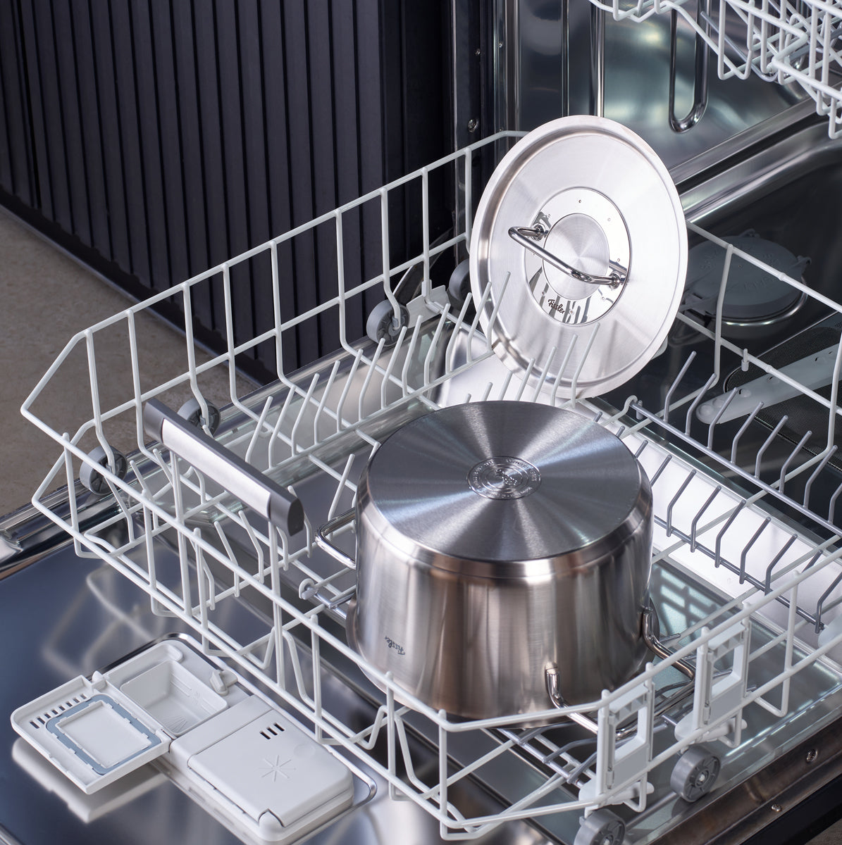 Das Fissler Pure Collection® Topf-Set aus recyceltem Edelstahl im unteren Geschirrkorb einer geöffneten Spülmaschine.