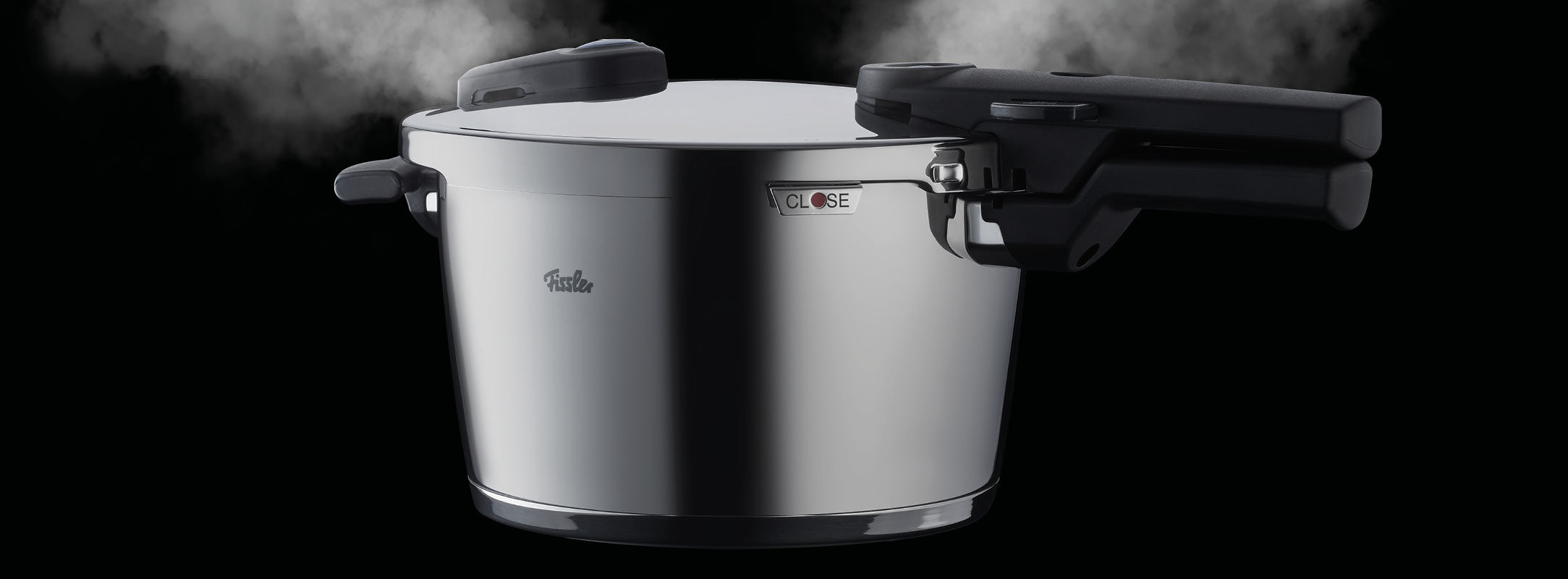 Der Fissler Schnellkochtopf aus Edelstahl mit ergonomischen schwarzen Griffen lässt den Dampf auf beiden Seiten ab und zeigt deutsche Handwerkskunst.