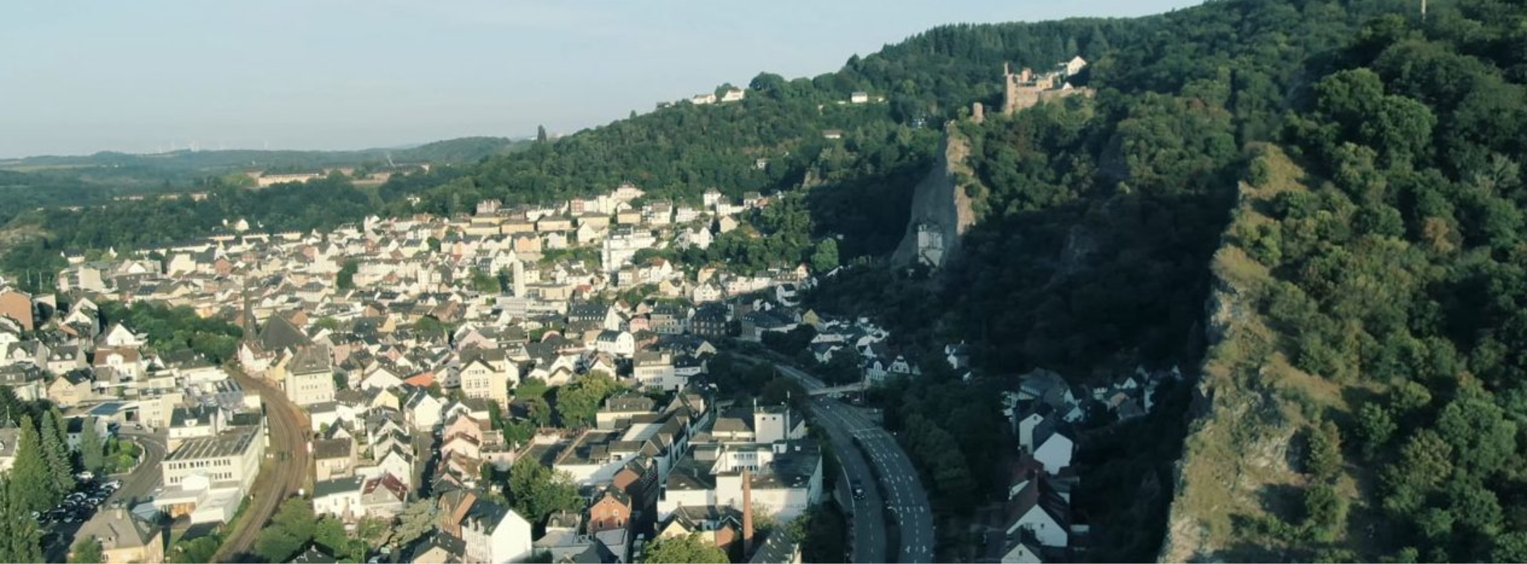 Aerial view of a German city with lush hills and castle ruins, reflecting Fissler's heritage of precision and timeless design.